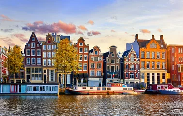 Fotobehang Amsterdam Amsterdam Nederland dansende huizen over rivier de Amstel landmark in het oude Europese lentelandschap van de stad.