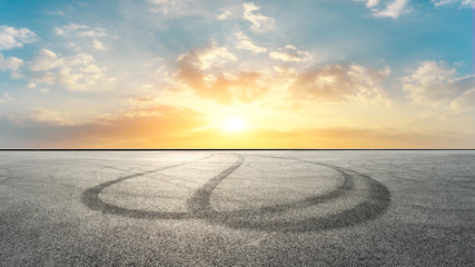 Fototapeta premium Asphalt race track ground and beautiful clouds at sunset