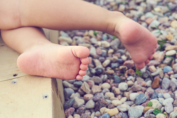 Baby's feet of a small child close-up on the pebble beach. Vacation on the Mediterranean sea