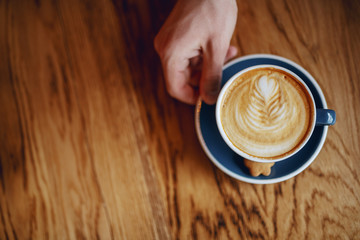 Top view of Caucasian man drinking coffee in cafeteria in morning.