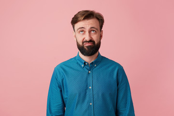 Bearded man wrinkle face looks dissatisfied, not inspired, without enthusiasm, with distrust, laziness, looking upward with tension, with a feeling of not wanting to fulfill the conditions