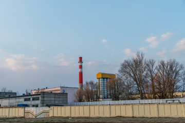 Red and white old brick industrial pipe on blue sky background. The old image of the Industry concept. Ecology, industrial renewal, globalization.