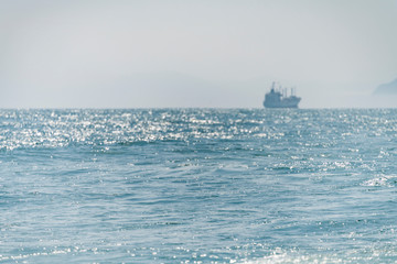 Sea ship sails. Along the shore at sun light