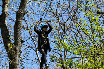 Fototapeta premium Parcours d'Accrobranche en forêt avec personne en action
