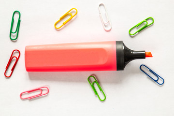 Red highlighter isolated on white background whith color paper clips.