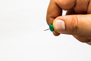 hand holding a green push pin. white background