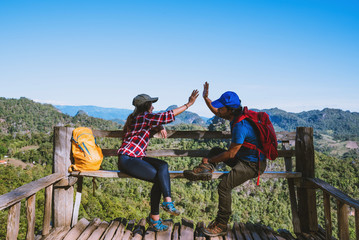 Asian couple Tourists with backpacks Happy to travel She raised her hand to make a heart shape and enjoy the natural scenery on the mountain.