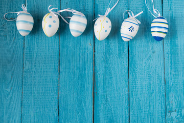 Colorful Easter Eggs arranged to one side on a blue background.