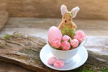 happy Easter holiday concept. Easter bunny, rose and colorful eggs in Cup. Easter still life. 