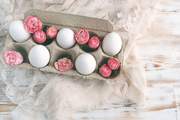 beautiful Easter still life. cute eggs in  cardboard box and rose flowers. decoration of Easter food. spring season. happy Easter spring holiday concept.