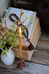 burning Church candle, willow and birch twigs  on dark background. Easter still life, palm Sunday. Church candle, symbol of faith and prayer. concept of faith in God, religious theme