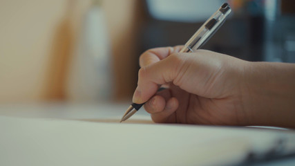 Close up of hand writing letter. Male hand signing important documents.