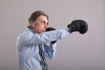 Businessman in Boxing gloves on grey background.