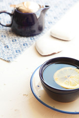Hot tea with a slice of fresh lemon at blue teacup with hearts of biscuits