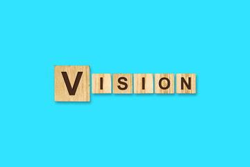 Vision. Words written on a wooden block. Blue background. Isolated. Business concept.