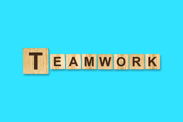 Teamwork. Words written on a wooden block. Blue background. Isolated. Business concept.