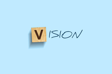 Vision. Words written on a wooden block. Blue background. Isolated. Business concept.