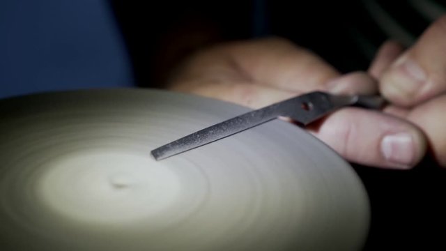 Close-up, worker polishing nail scissors, slow-motion. Concept of recovery manicure tools