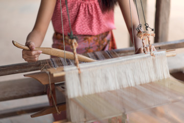 Women's hands weaving with traditional Thai weaving machine