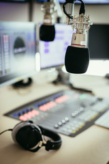 Radio broadcasting studio: Microphone in the foreground, modern studio in the blurry background