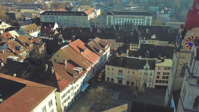 Drone flight with aerial view above church in old town of Winterthur in Switzerland. Tower and building roofs from above. Dynamic shots of European town.