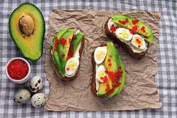 Healthy avocado toast with quail eggs and red caviar. Keto diet. Keto toasts