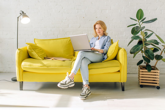 Young Lady Reading A Book On Cozy Yellow Couch
