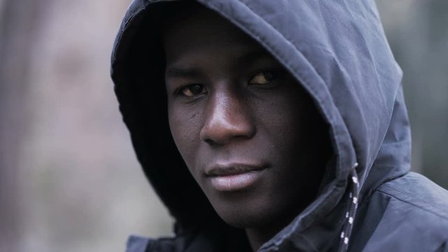 Confident attractive young african black man with hood looking at camera-outdoor