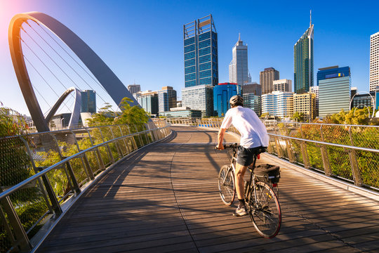 A man cycling on an elizabeth bridge in Perth city