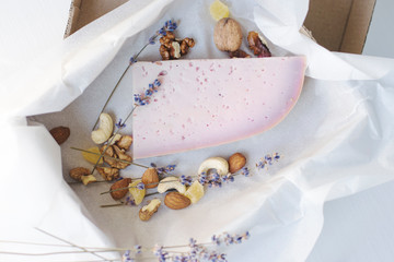 Lavender cheese with nuts in a box on a light background