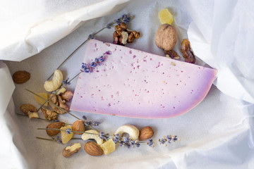 Delicious lavender cheese close-up with nuts in wrapping paper