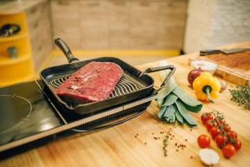 Roasted meat in a frying pan on electric stove