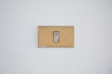 The old and dirty light switch on wall