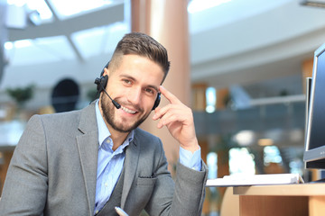 Smiling friendly handsome young male call centre operator.