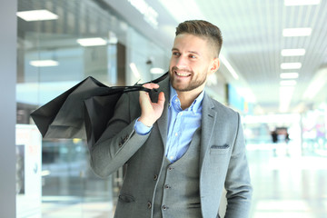 Handsome man in suit with shopping bags.