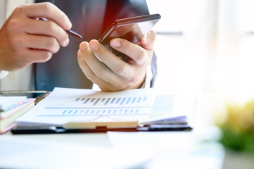 Closeup image of businessman using stylus working on mobile smartphone while sitting at office...