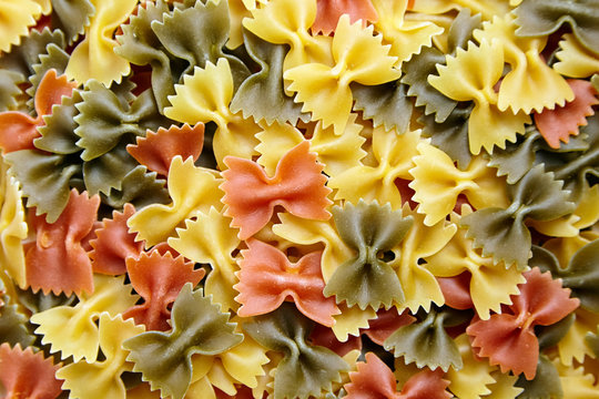 Uncooked Farfalle Tricolore Pasta background. Top view