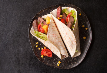 Mexican tacos with beef, vegetables and pineapples and corn grains. Taco al pastor on a wooden...