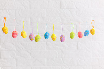 Colorful easter eggs hanging on silk ribbons with bows isolated
