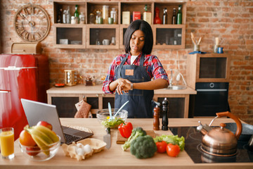 Black woman in apron cooking healthy breakfast