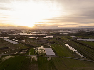 Spring sunset in green valley with green fields