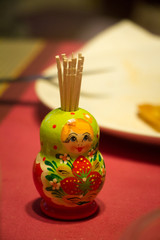Toy Matryoshka on the table as a stand for toothpicks.