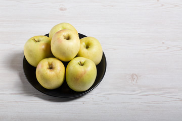 Raw delicious apples golden on wood background