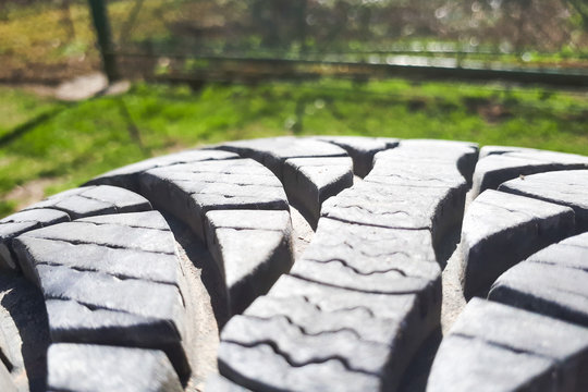 Close-up winter tire tread. Textured tire tread on green and bokeh background.