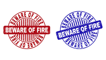 Grunge BEWARE OF FIRE round stamp seals isolated on a white background. Round seals with grunge texture in red and blue colors.