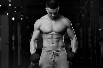 Fototapeta na wymiar Shirtless Athletic Young Man With Dumbbells