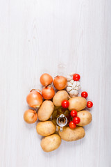 Fresh vegetables ingredients on white wood background