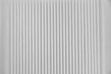 Obraz premium Close-up on a car filter for a white engine as a background with vertical stripes. Spare parts for vehicles, repairs and maintenance.