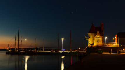 Fototapeta na wymiar The harbor of Stralsund with the Lotsenhus at night, in the background the Rügen bridge