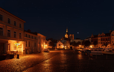 Fototapeta na wymiar The old town of Stralsund at night beautifully lit with lanterns and charming cobblestones